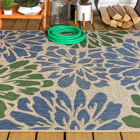 JONATHAN Y rinsing rug with hose showing easy-clean outdoor washing benefit