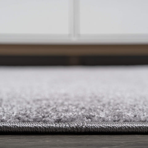 JONATHAN Y hands spot-cleaning rug showing easy-care stain removal method