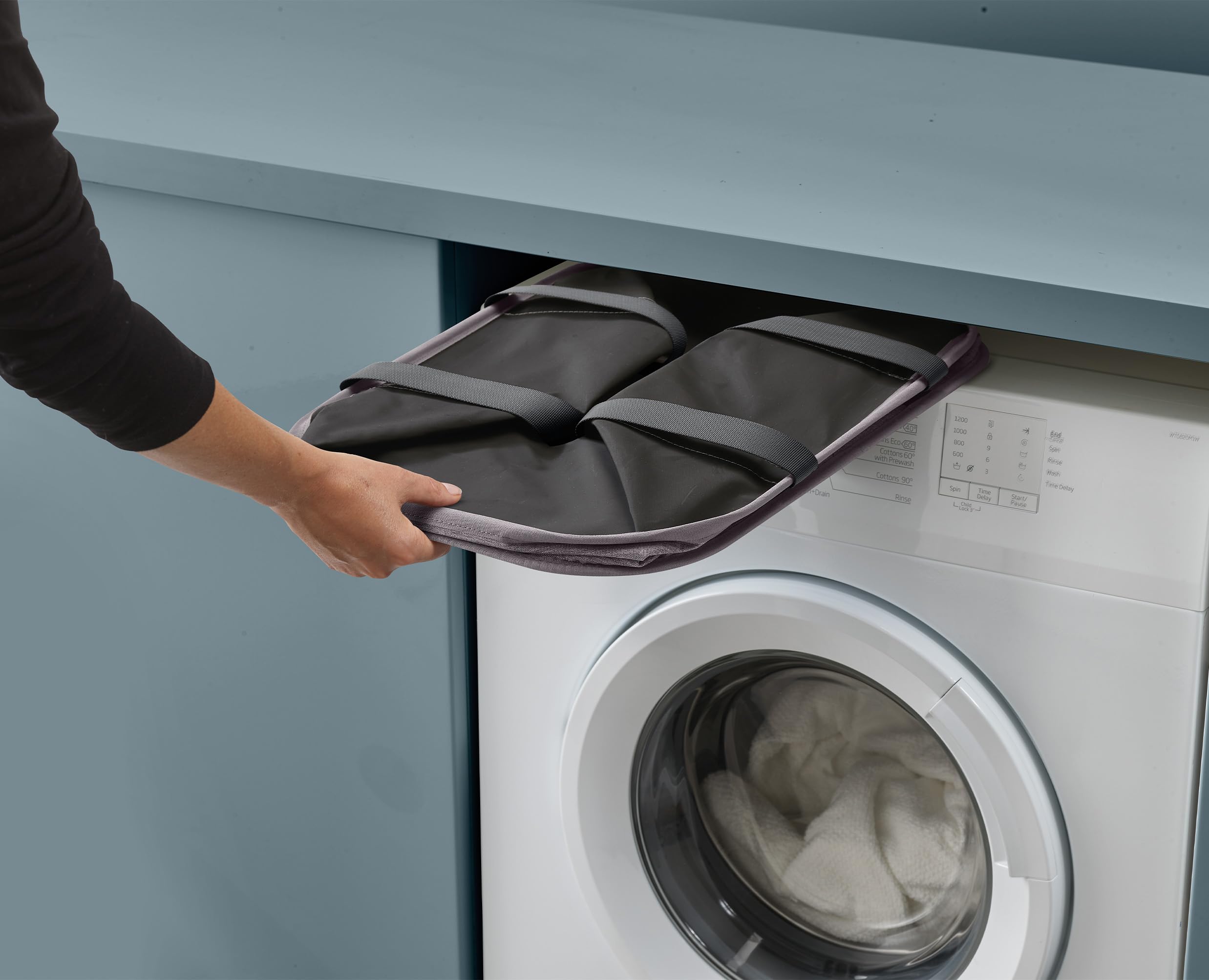 Joseph Joseph next to washing machine showing scale and space-saving benefit