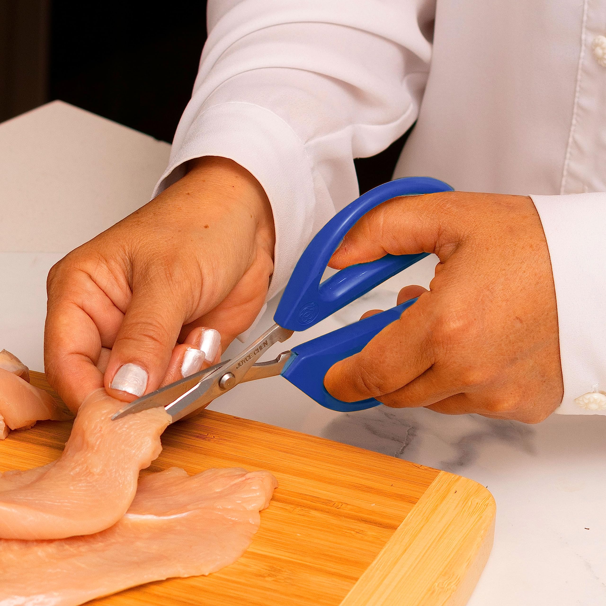 JOYCE CHEN scissors beside chef knife showing scale and compact kitchen convenience