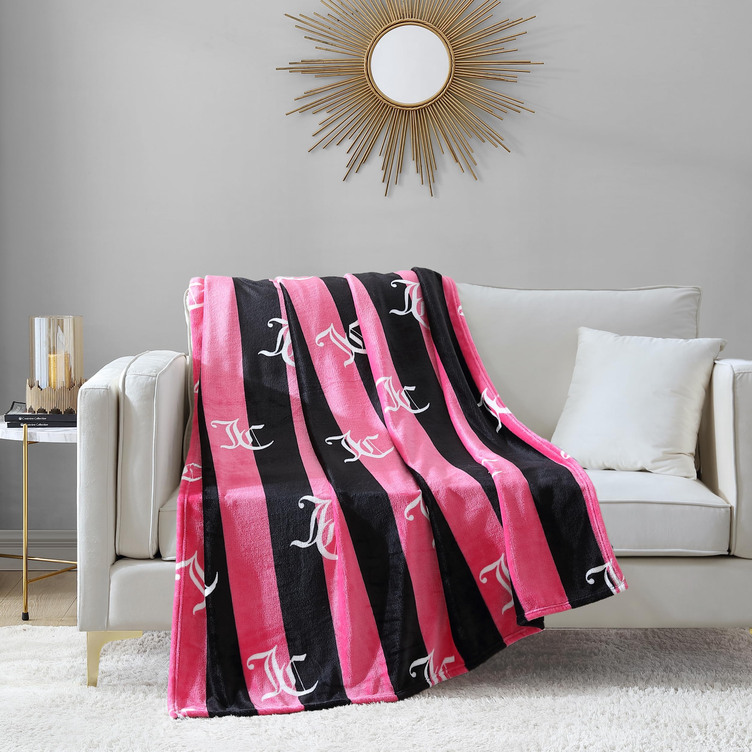 Juicy Couture folded throw next to a book for size and scale reference