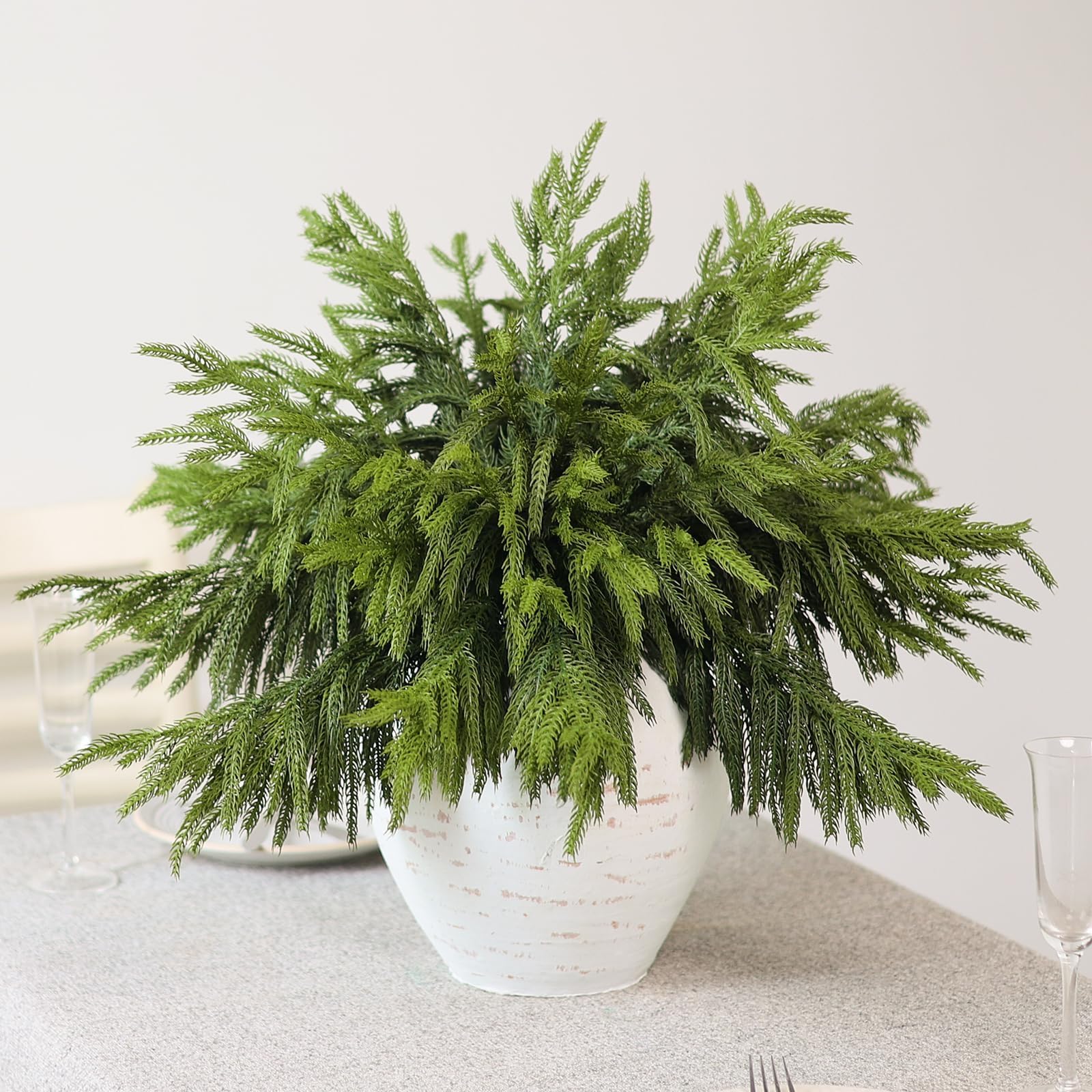 Juxdp stems arranged in clear vase adding instant evergreen volume to decor