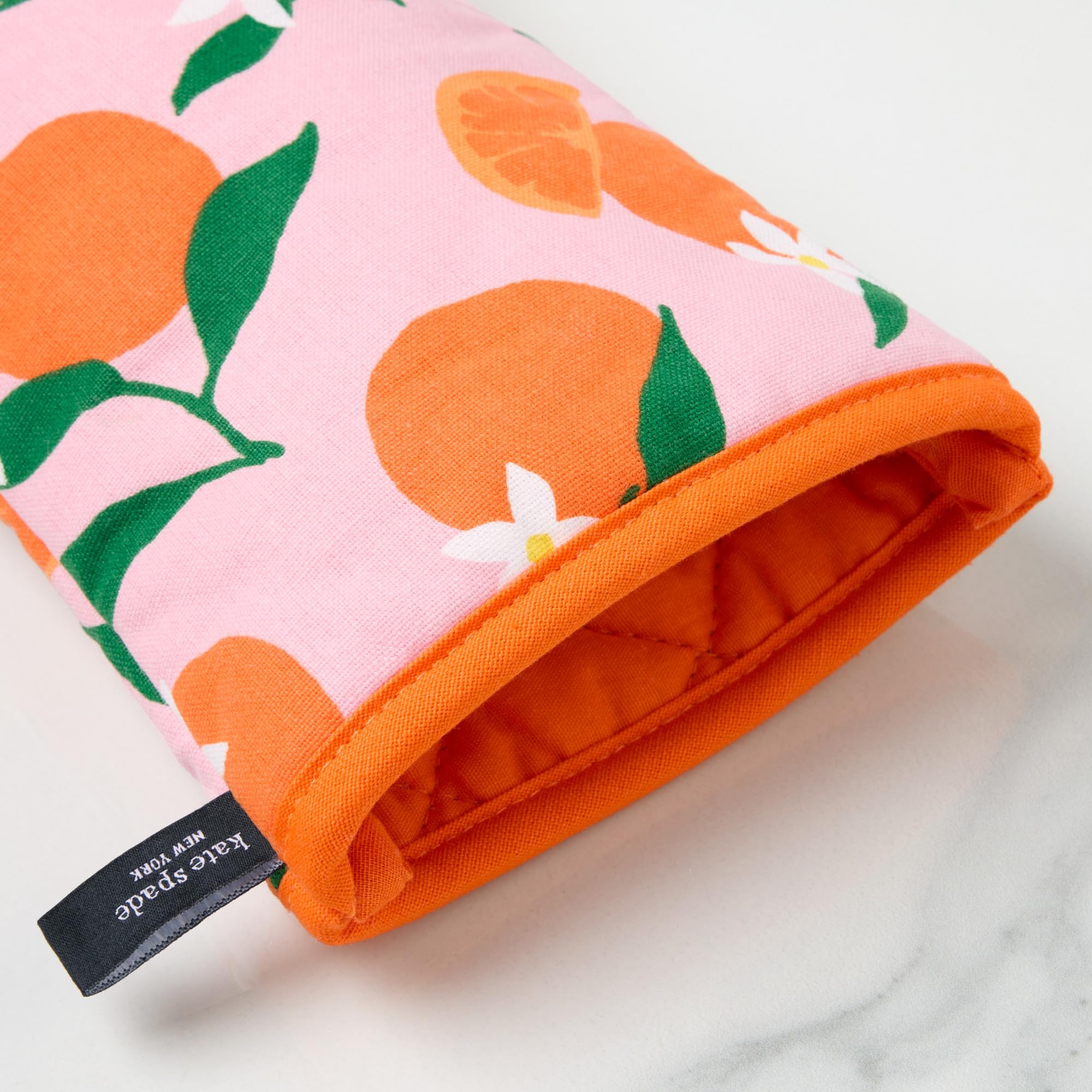 kate spade new york oven mitt in use holding hot baking dish for safe handling