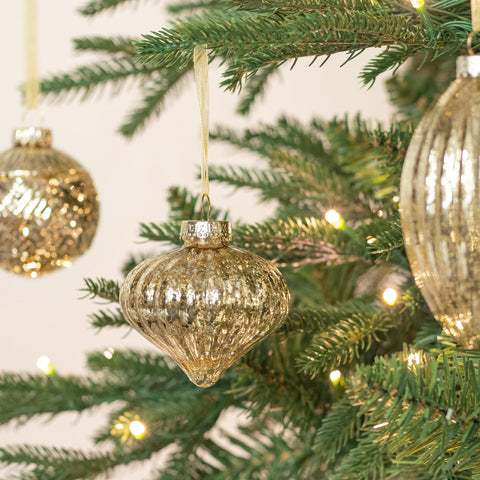KI Store ball ornament hanging on tree adding elegant reflective sparkle