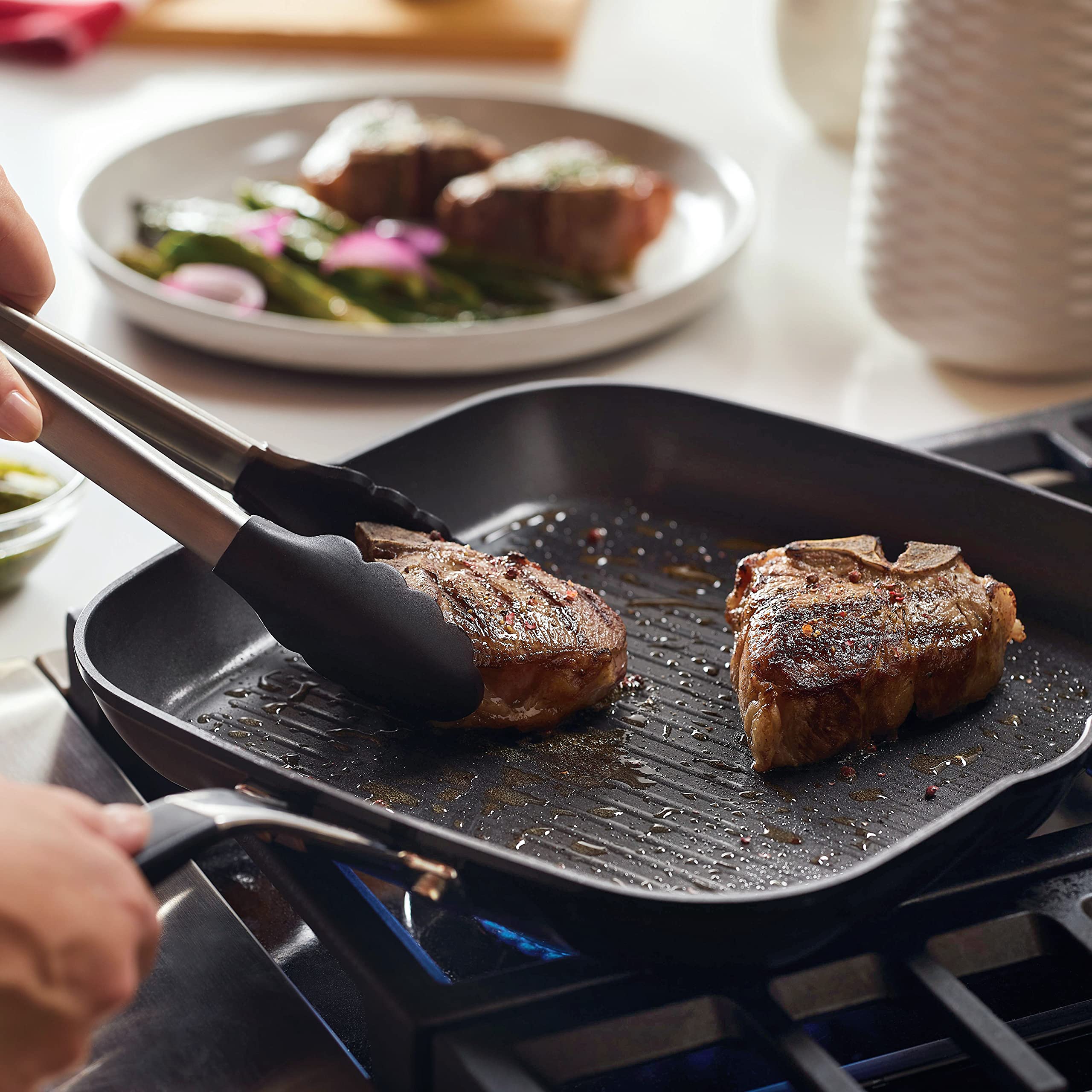 KitchenAid in-use shot searing steak on stovetop demonstrating clear grill marks