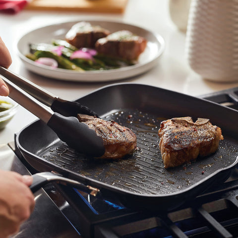 KitchenAid in-use shot searing steak on stovetop demonstrating clear grill marks