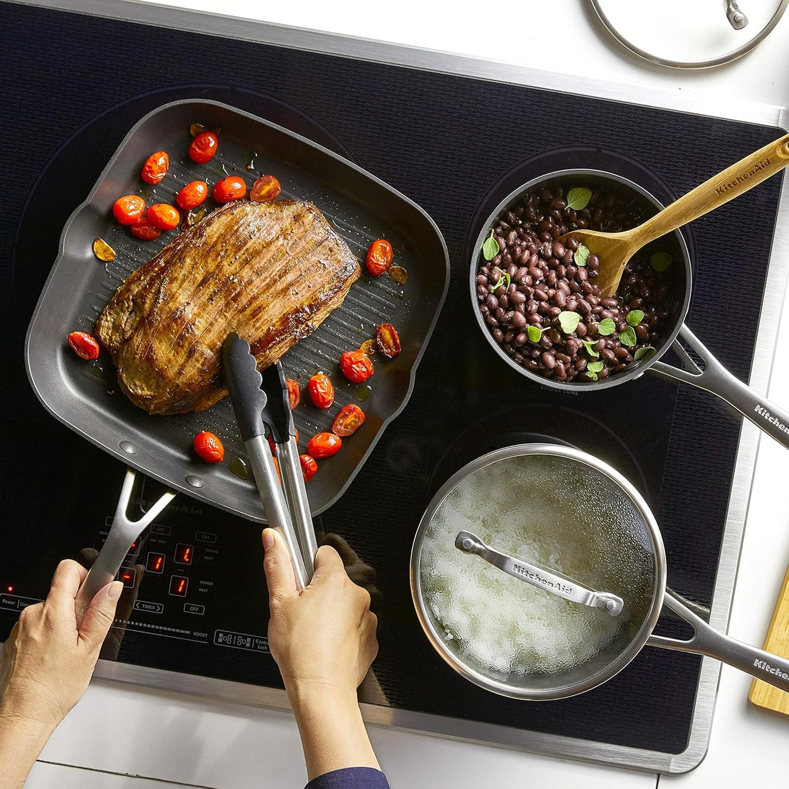 KitchenAid pans on induction cooktop illustrating compatibility and fast heating