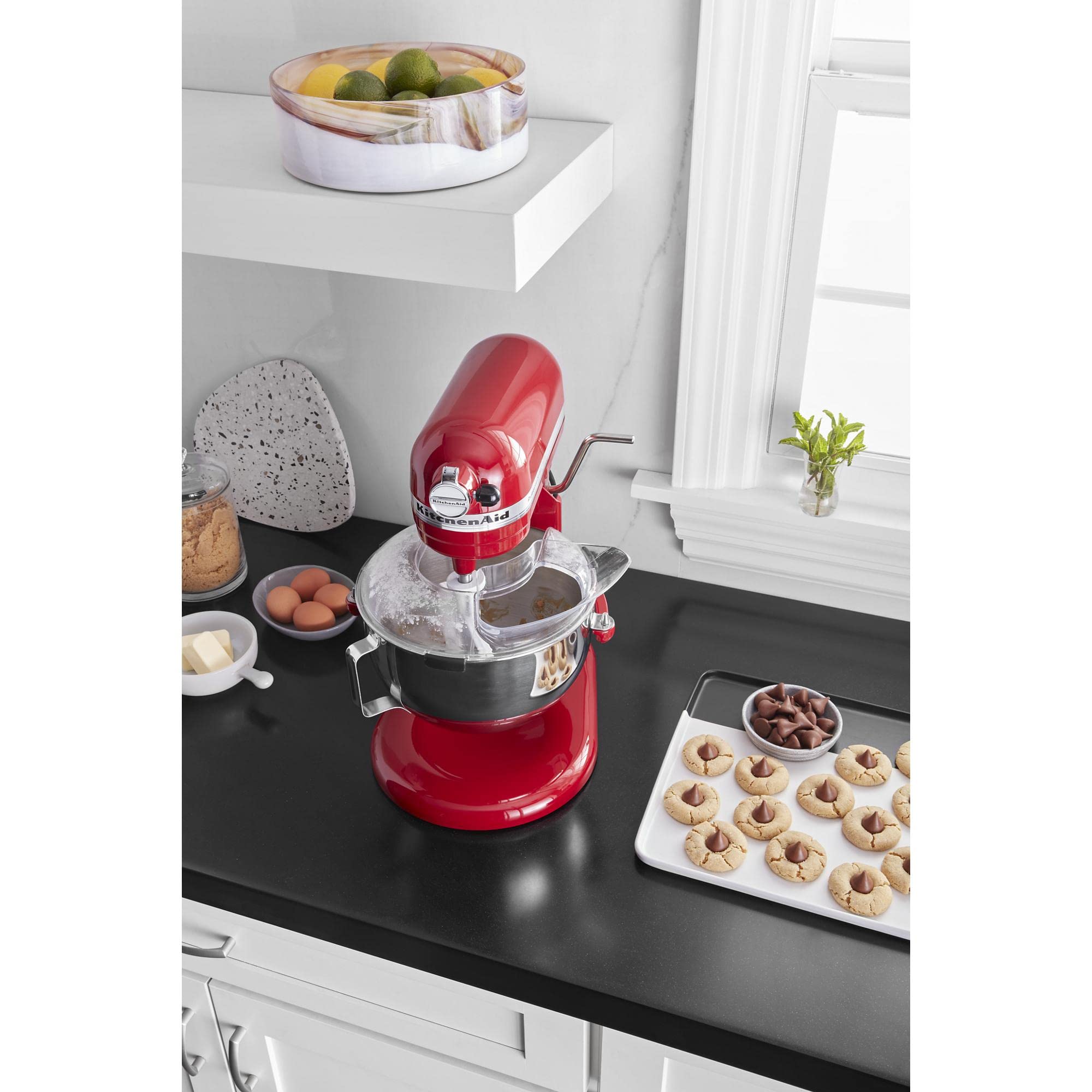 KitchenAid pouring shield beside stainless bowl to show size and compatibility