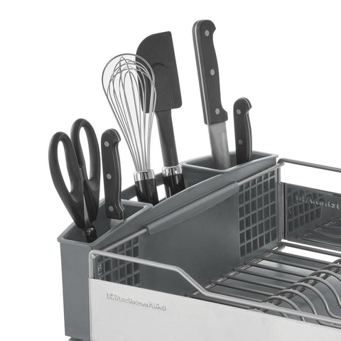 KitchenAid dish rack beside plates for size comparison and clear capacity indication