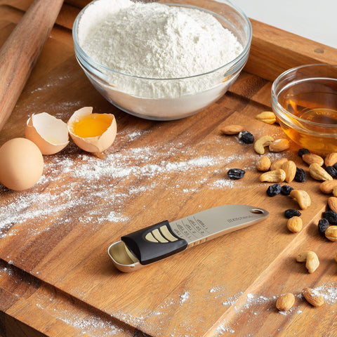 KitchenArt scooping spices with adjustable spoon showing effortless seasoning portioning