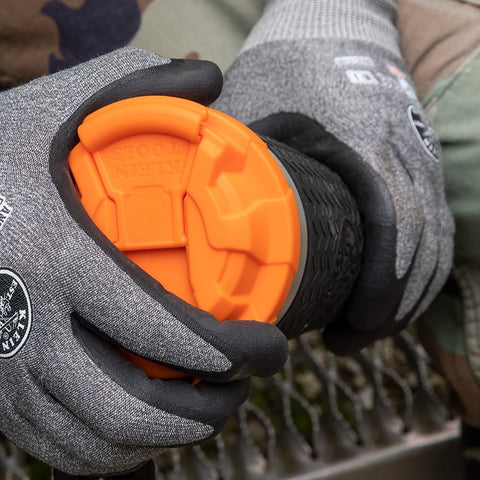 Klein Tools tumbler held in gloved hand demonstrating secure handling benefit