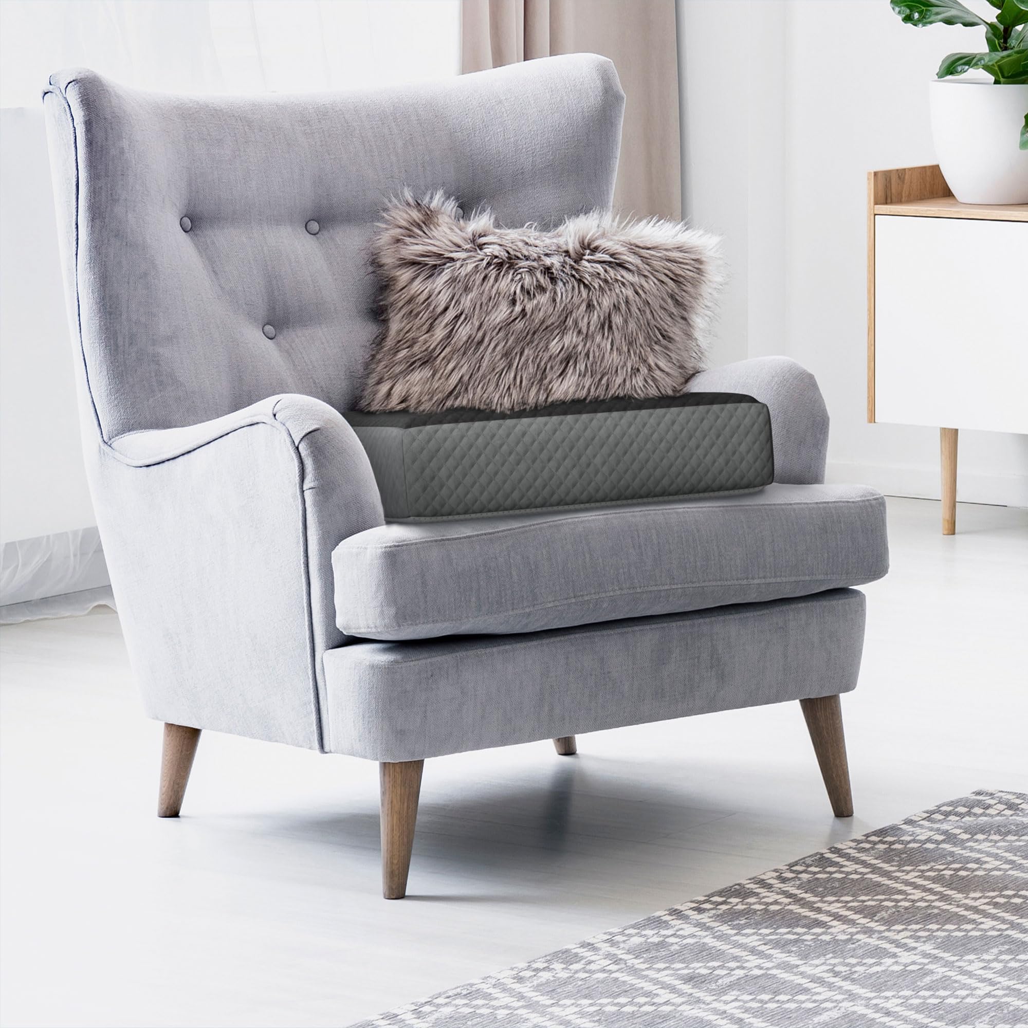 Kölbs cushion beside footstool illustrating large size and scale compatibility