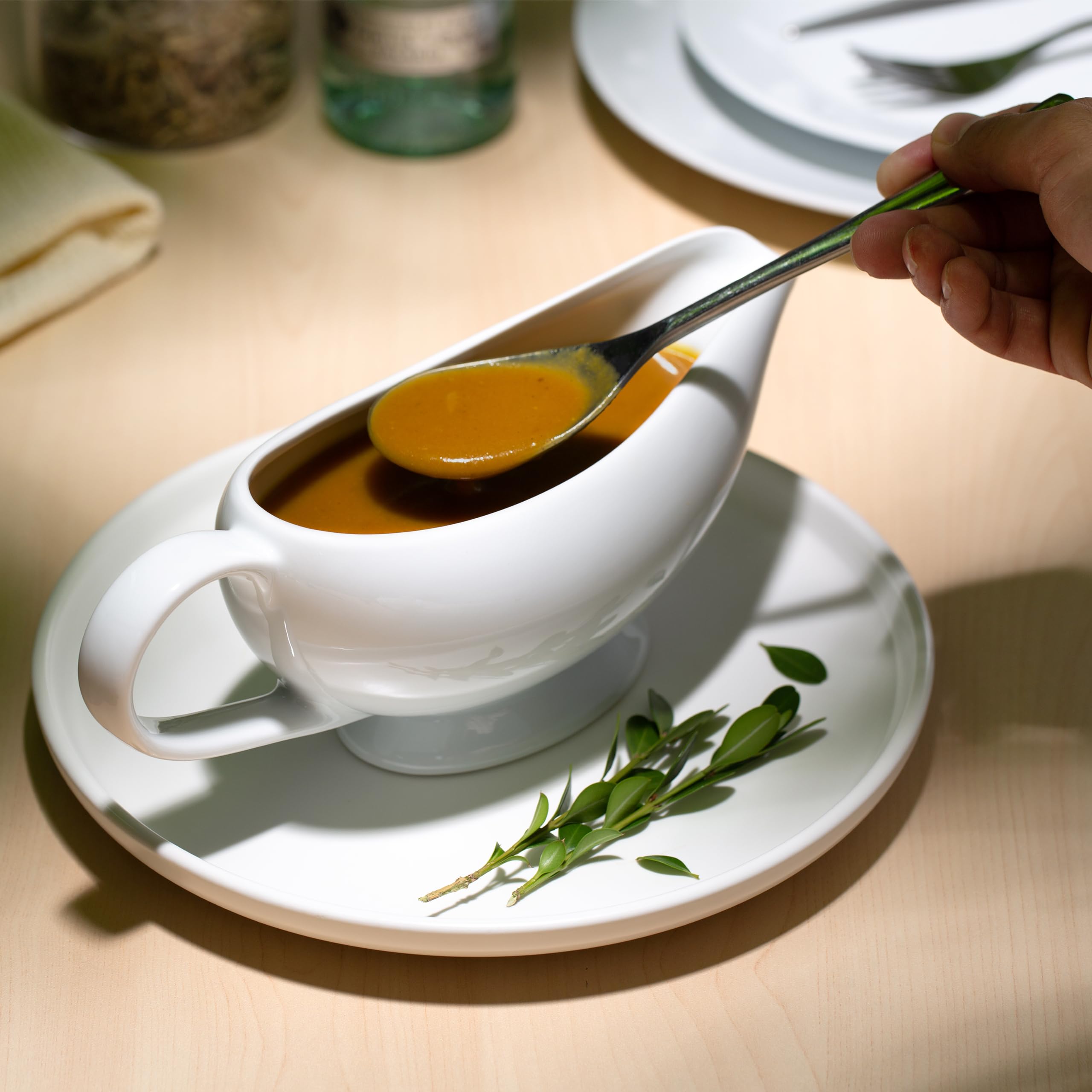 Kook gravy boat in use pouring sauce to plate for controlled serving benefit