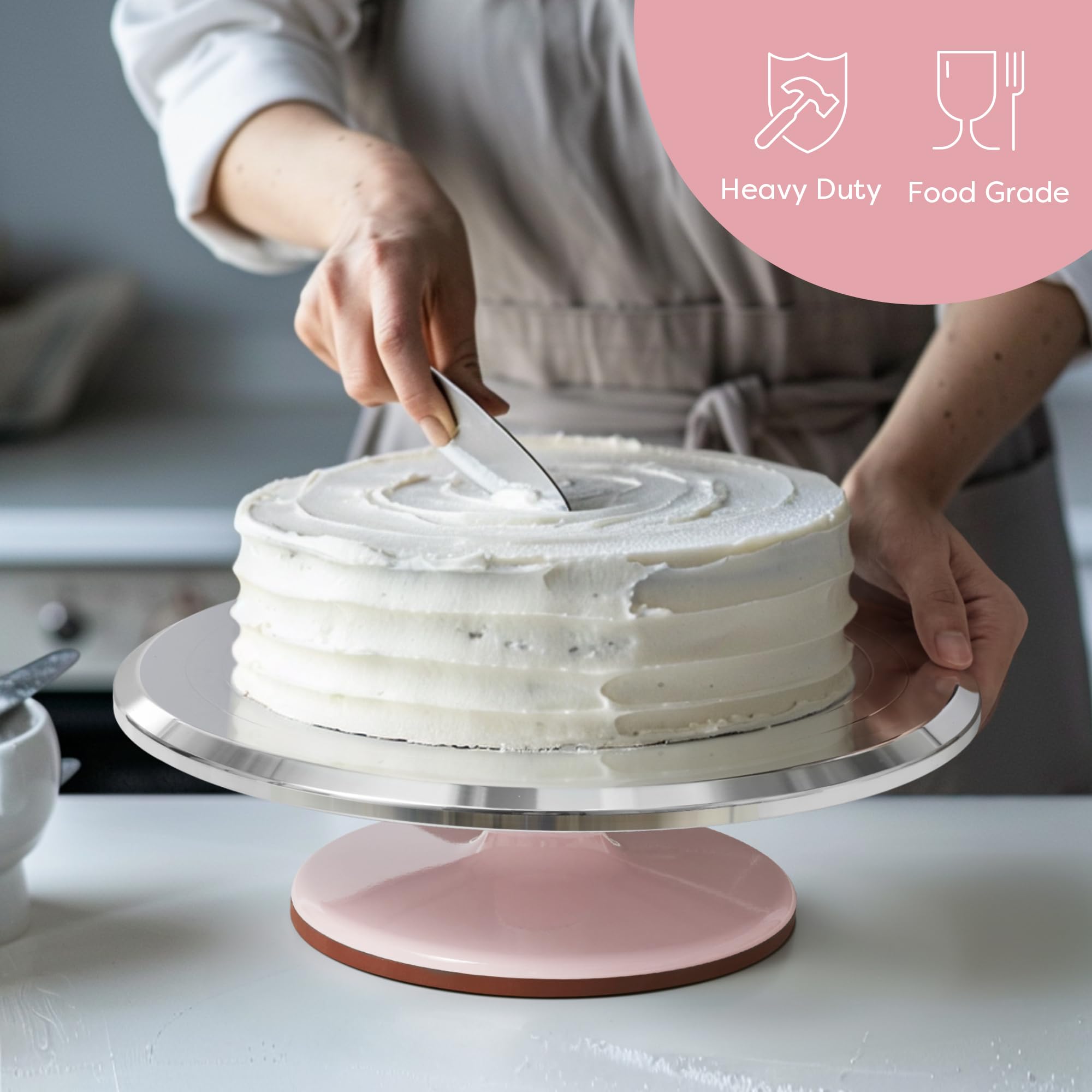 Kootek turntable in use with baker spinning cake for efficient, even icing