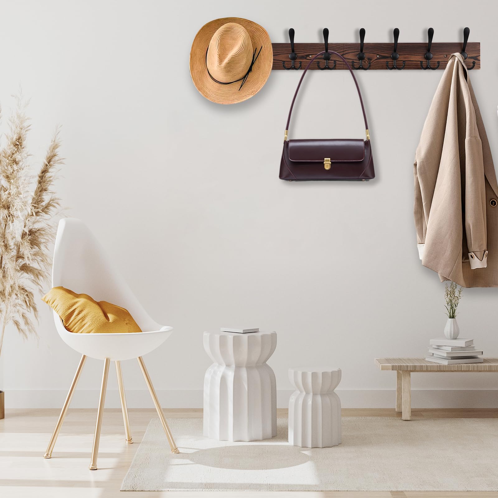 Kuhome mounted in an entryway with coats and bags hung, demonstrating space-saving organization