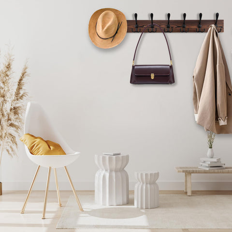 Kuhome mounted in an entryway with coats and bags hung, demonstrating space-saving organization