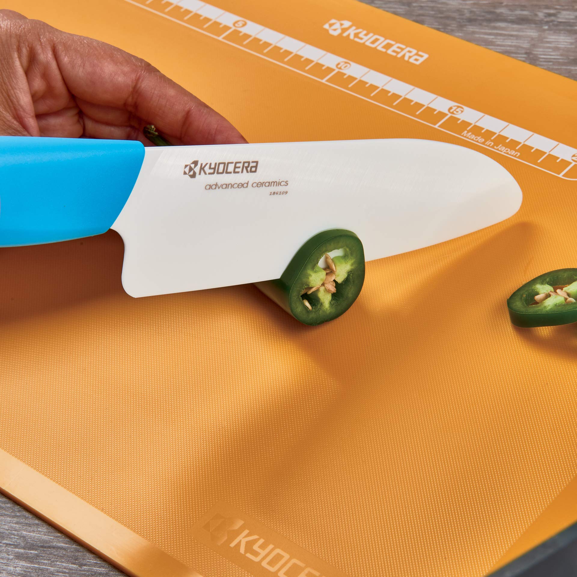 KYOCERA knife in use chopping vegetables to show clean cuts and ergonomic control