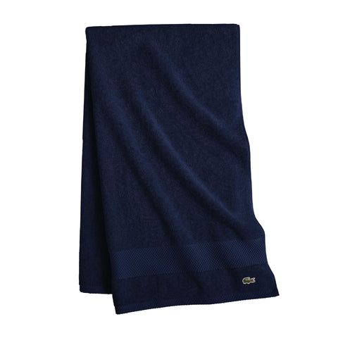 Lacoste folded navy towel front view showing plush feel and refined look