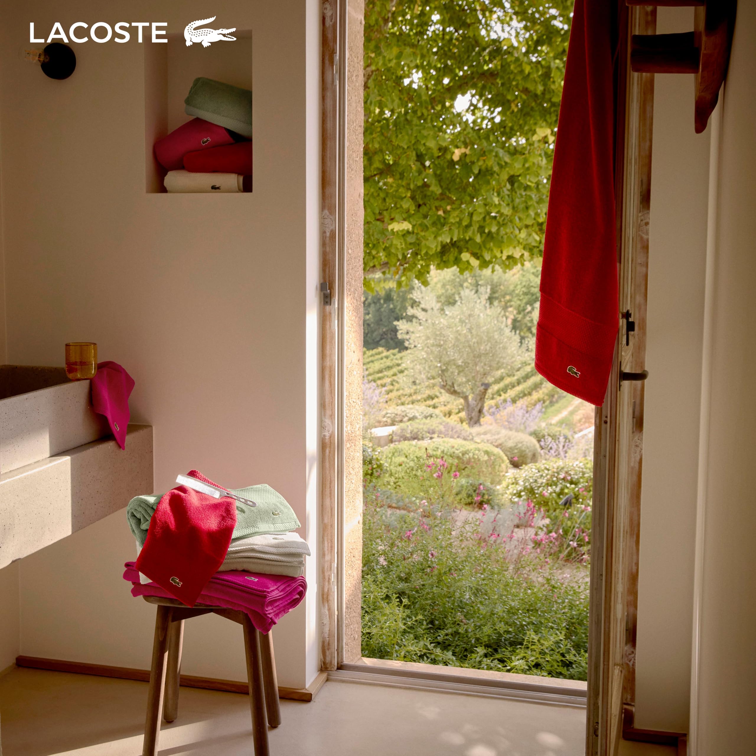 Lacoste towel held by hands comparing size and showing scale