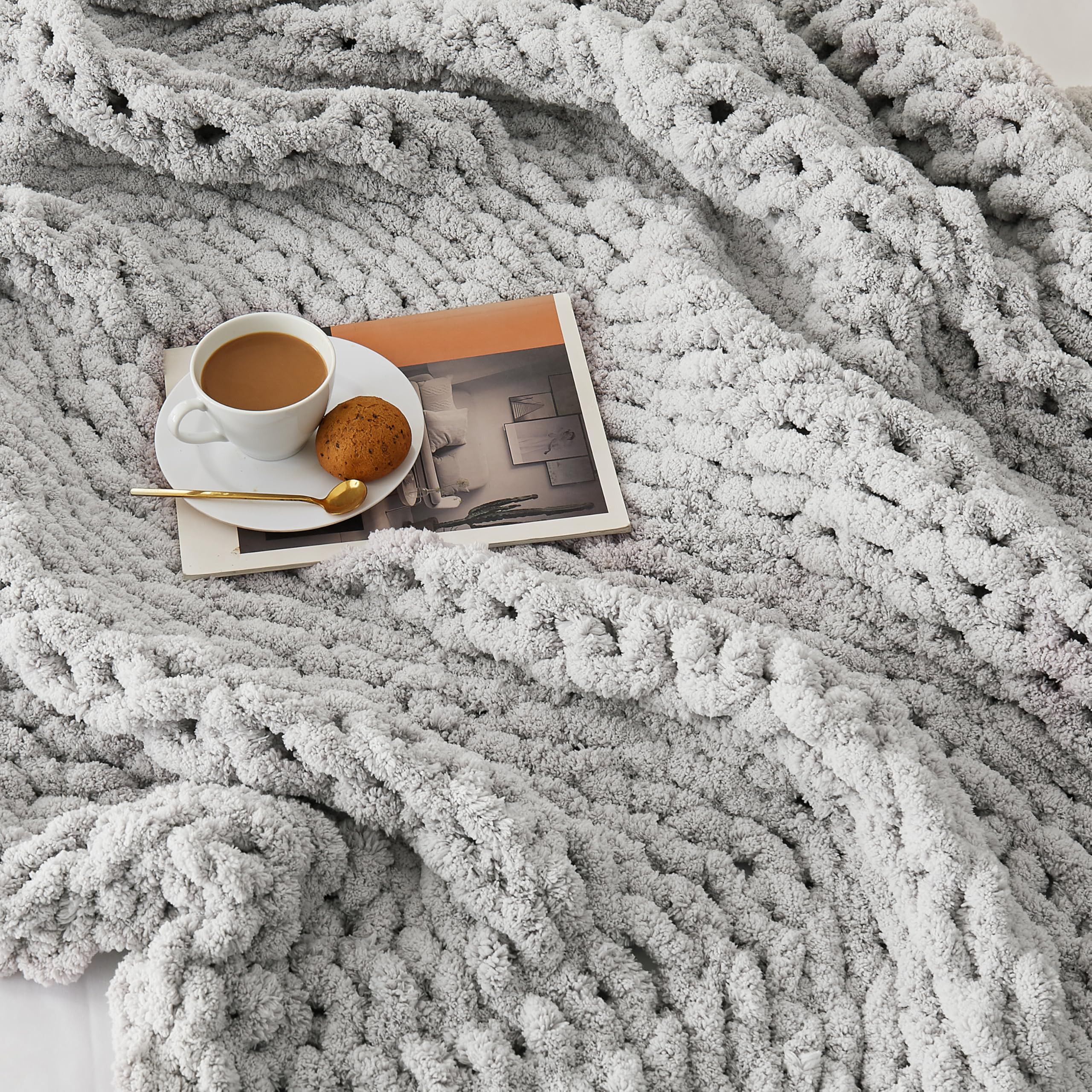 L'AGRATY throw draped on a sofa demonstrating warmth and decorative styling