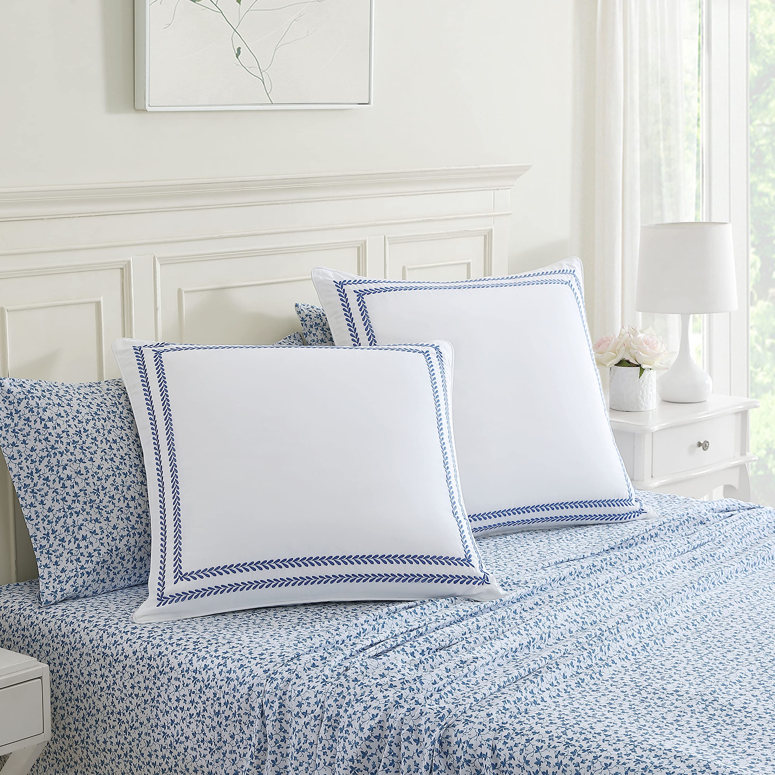 Laura Ashley styled on bed with layered pillows showing decorative impact and coordination