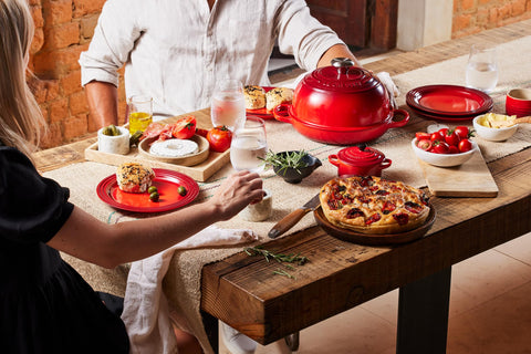 Le Creuset lid partially lifted with steam to show crust development