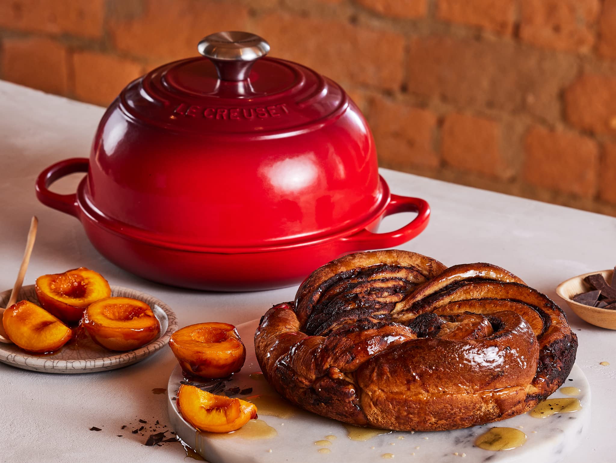 Le Creuset next to hand for scale demonstrating compact bake capacity