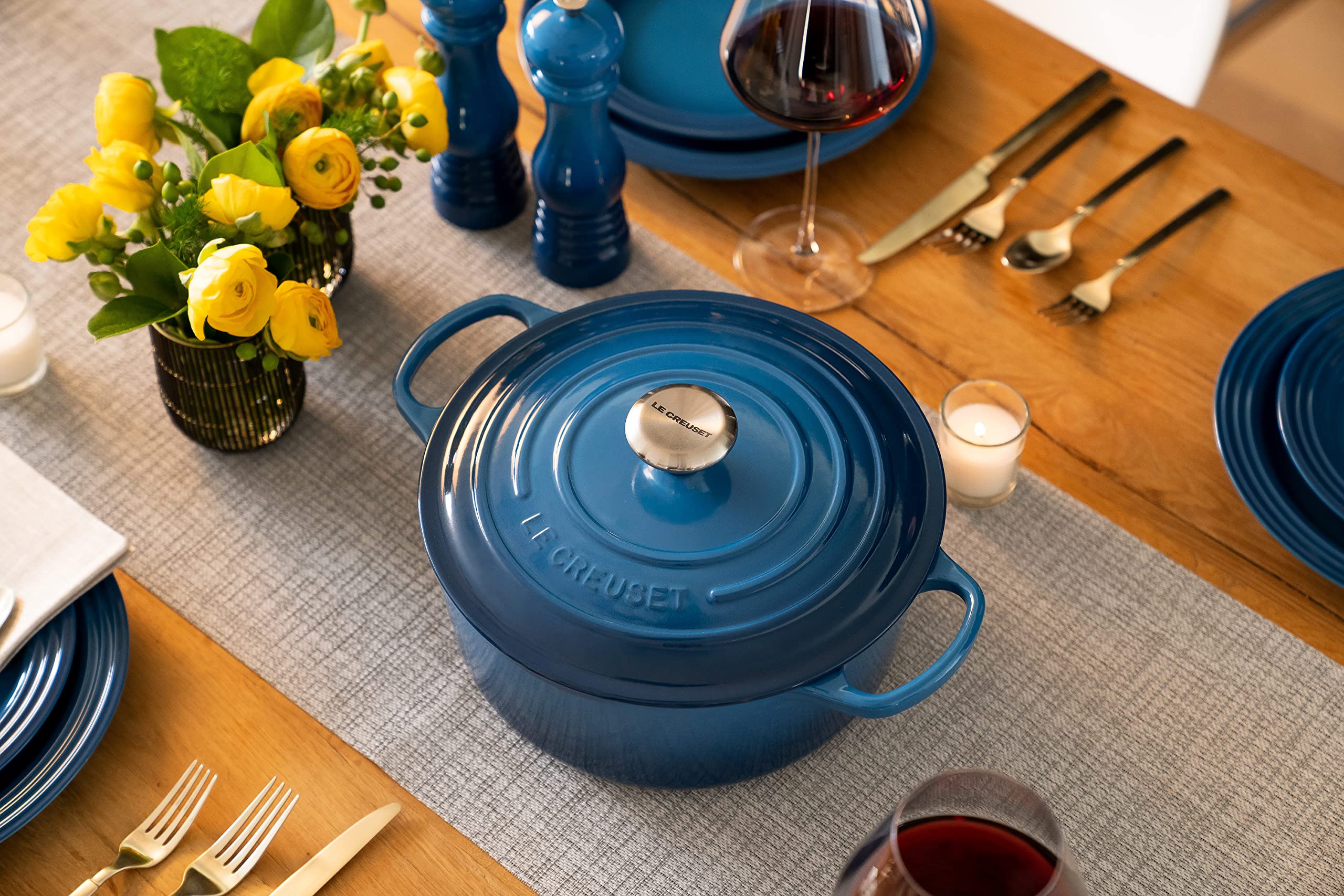 Le Creuset Dutch oven braising chicken on stovetop showing even heat distribution benefit