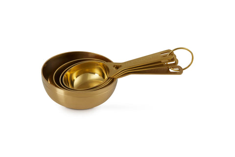 Le Creuset gold measuring cups in a kitchen scene adding style and functionality