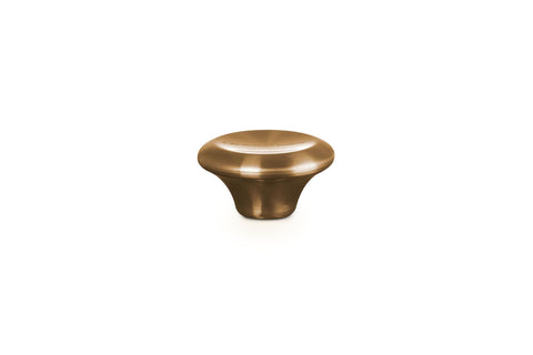 Le Creuset close-up of gold knob texture showing stainless steel detail and polish