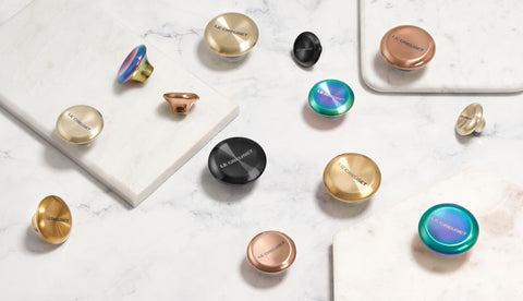 Le Creuset gold knob beside ruler size comparison showing 2.25-inch scale and fit