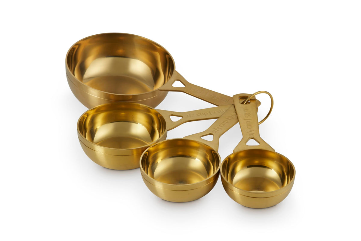 Le Creuset gold measuring cups front view showing polished finish and accuracy