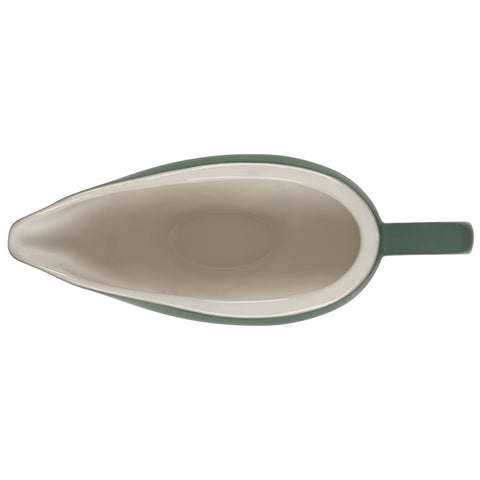 Le Creuset gravy boat in use on table serving sauce with easy grip and steady pour