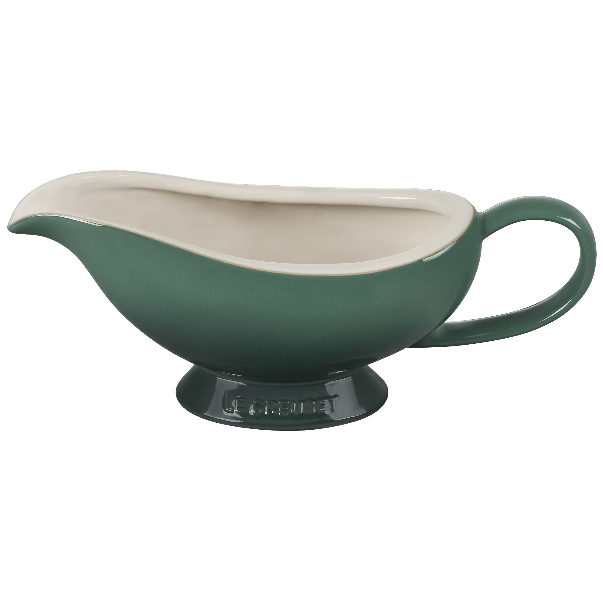 Le Creuset gravy boat held in hand to show size and comfortable handle for controlled serving