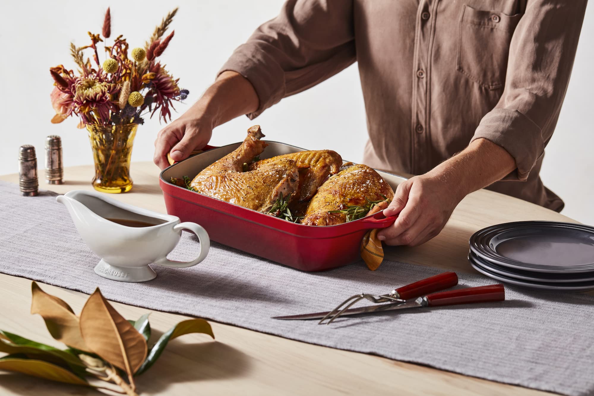 Le Creuset gravy boat beside fork for size comparison and tabletop fit