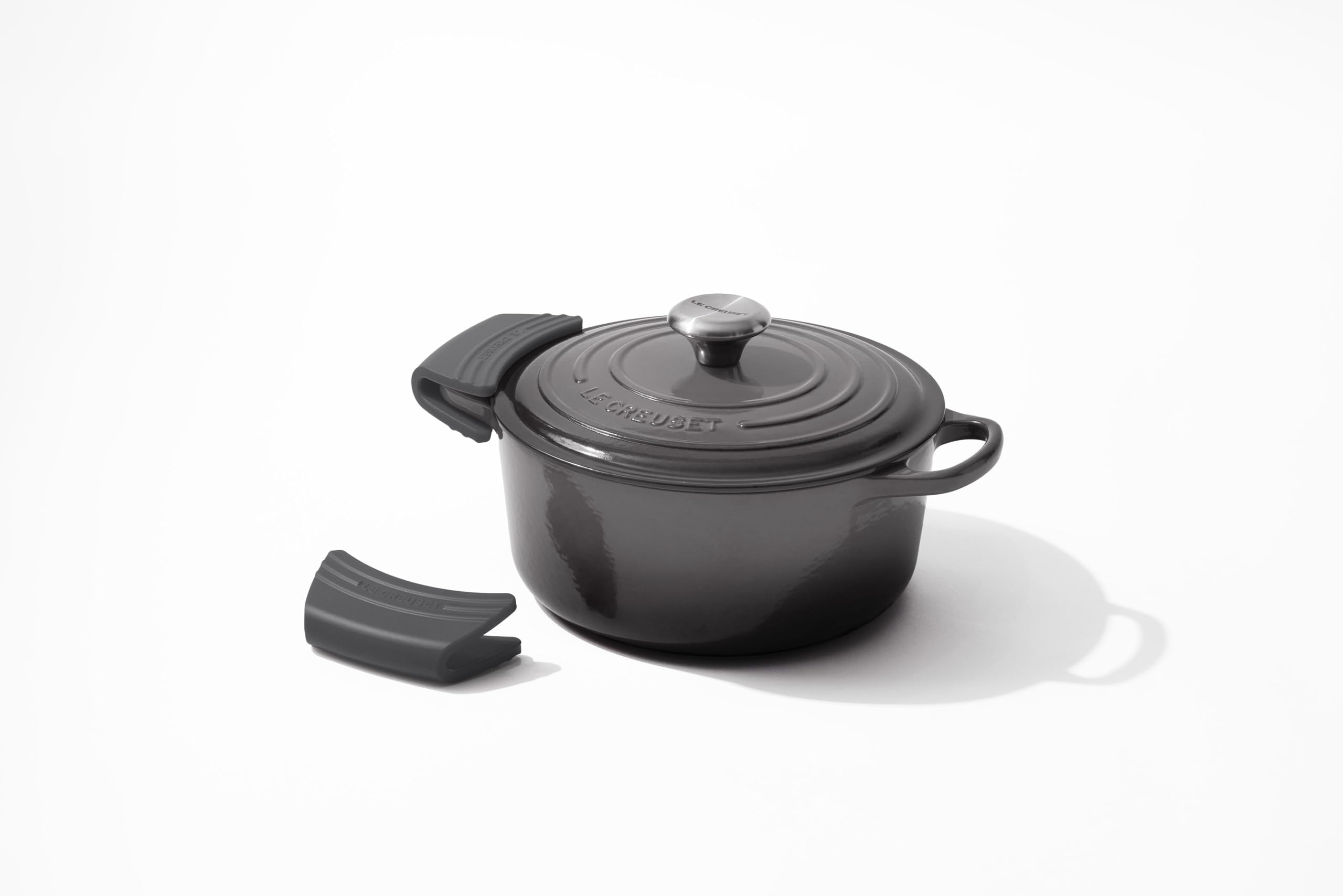 Le Creuset grips beside a hand for size comparison illustrating comfortable fit