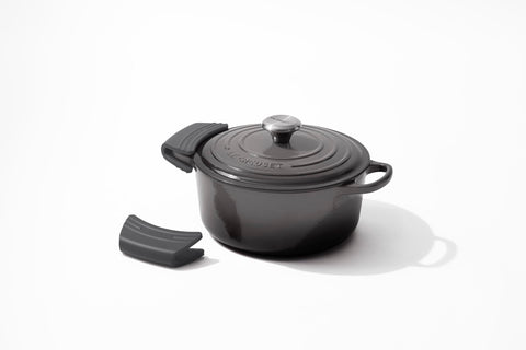 Le Creuset grips beside a hand for size comparison illustrating comfortable fit
