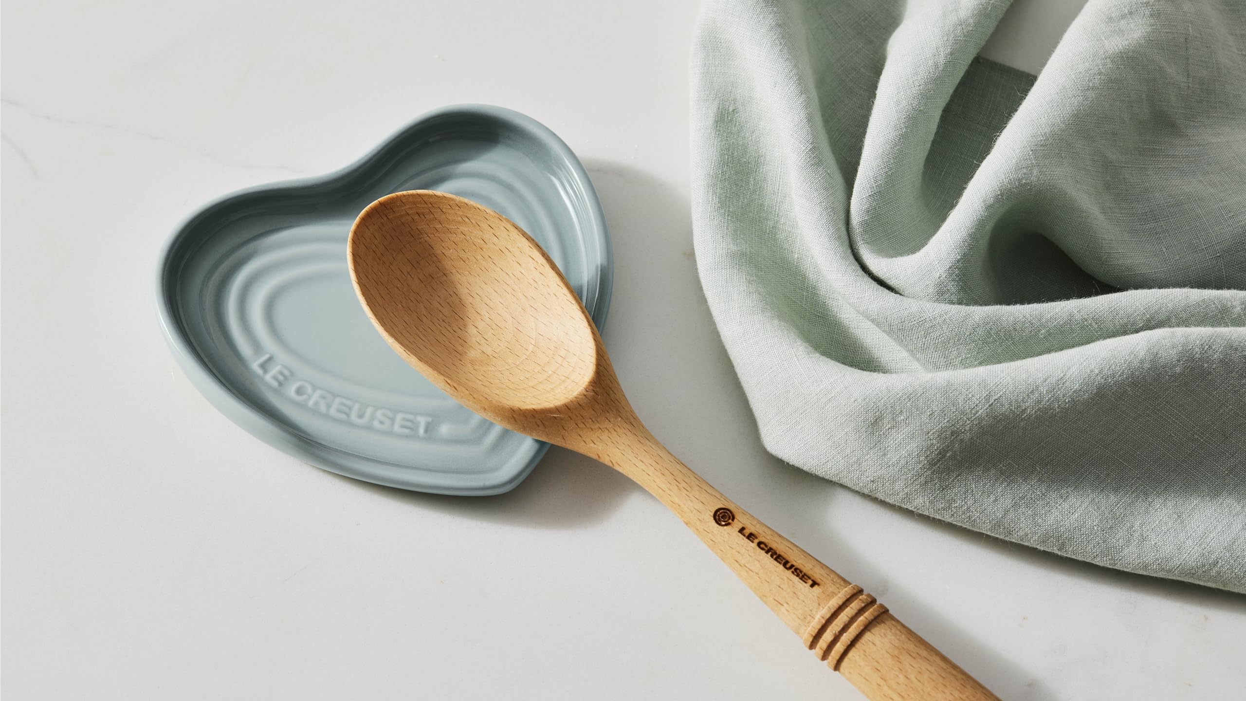 Le Creuset spoon rest beside utensils demonstrating compact 5-inch scale and space-saving benefit