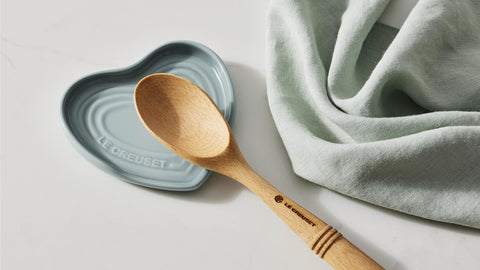 Le Creuset spoon rest beside utensils demonstrating compact 5-inch scale and space-saving benefit