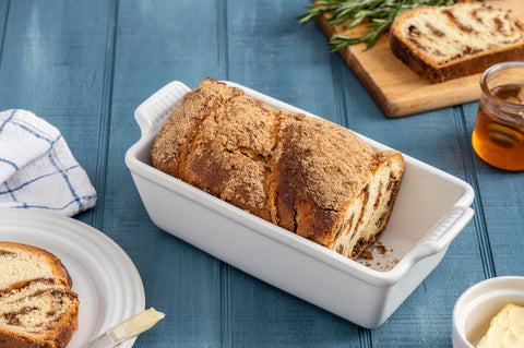 Le Creuset pan on table with sliced loaf highlighting serving presentation