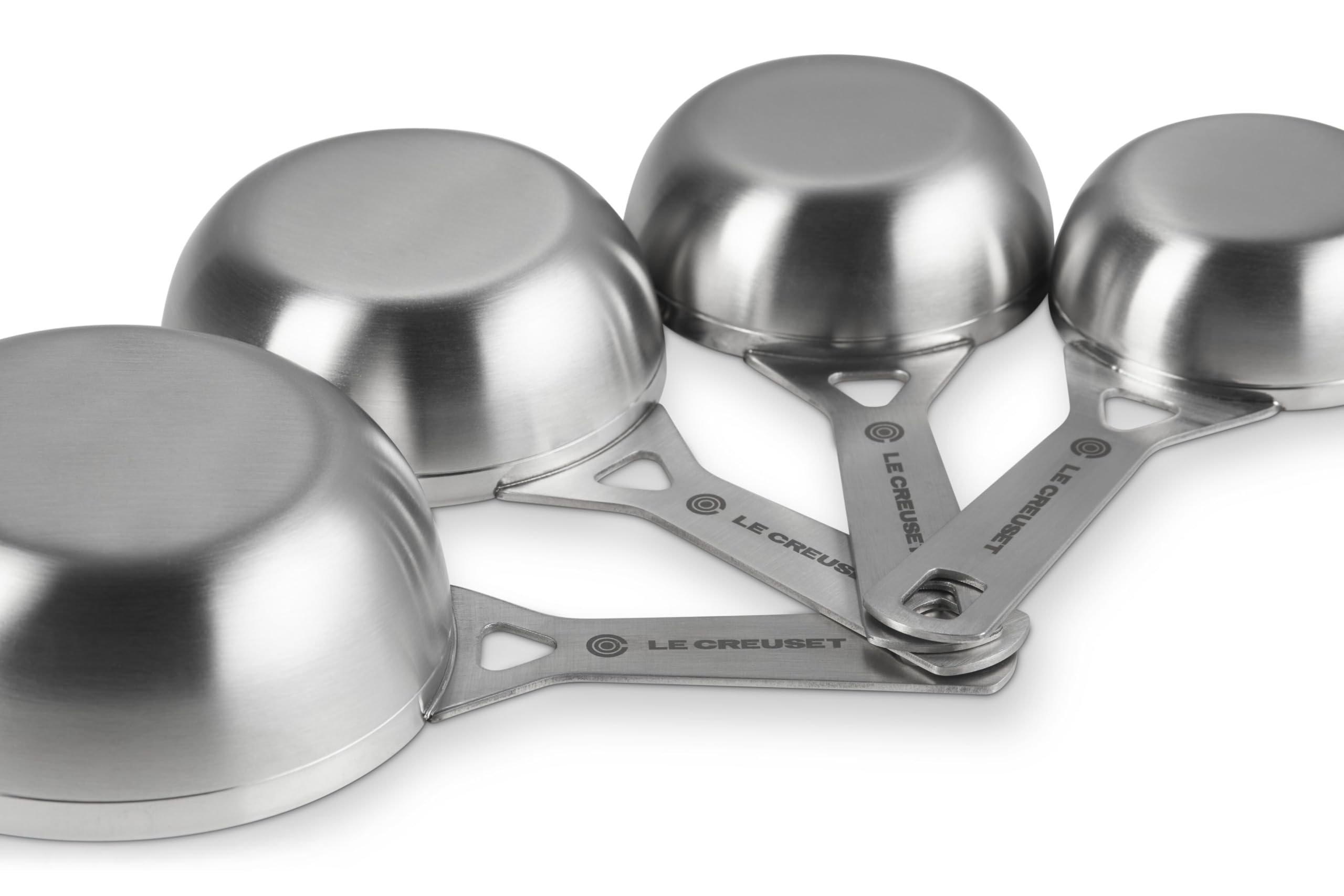 Le Creuset cup scooping flour with steady grip for precise measuring