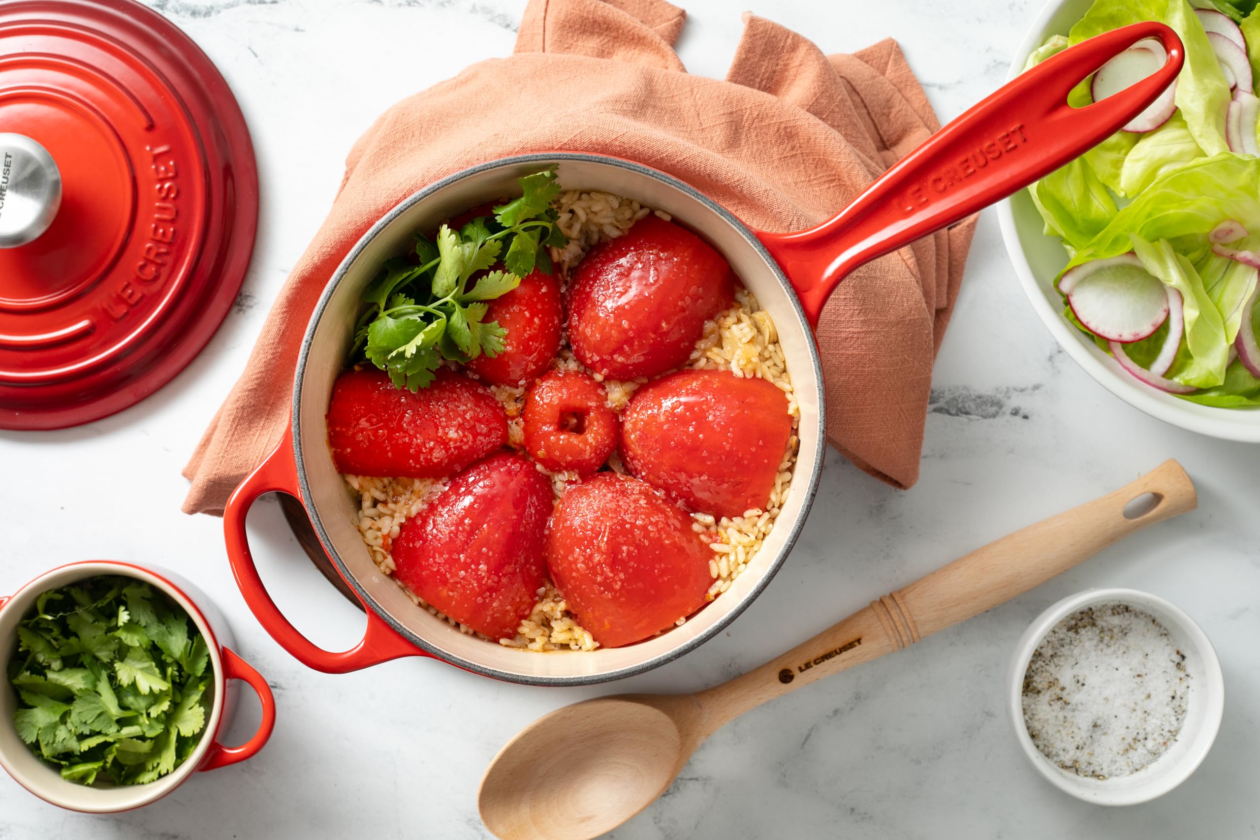 Le Creuset saucepan handles close-up showing contoured grip and helper handle for stability
