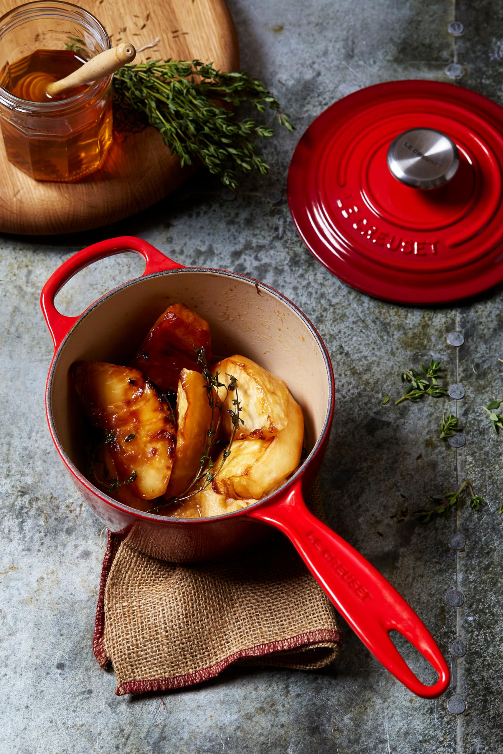 Le Creuset saucepan on stovetop with simmering sauce illustrating consistent heat control