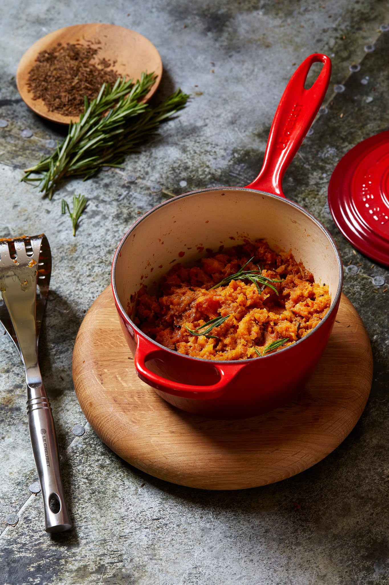 Le Creuset saucepan on table in a serving scene emphasizing stovetop-to-table appeal