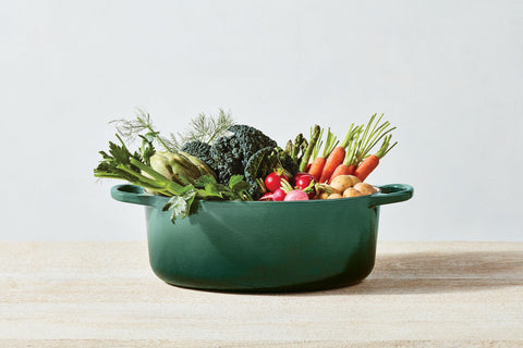 Le Creuset next to wooden spoon showing 8 qt scale for family meals