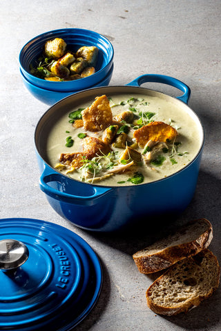 Le Creuset Dutch oven beside fruit to show 5.5 qt scale and family-serving capacity benefit