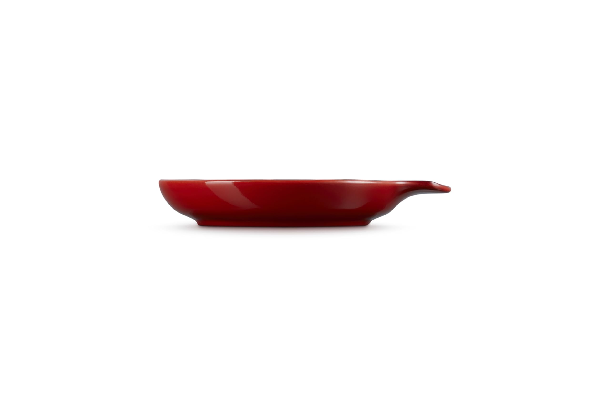 Le Creuset spoon rest holding a wooden spoon to protect counters