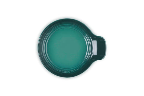 Le Creuset spoon rest in kitchen use holding a wooden spoon to keep counters clean
