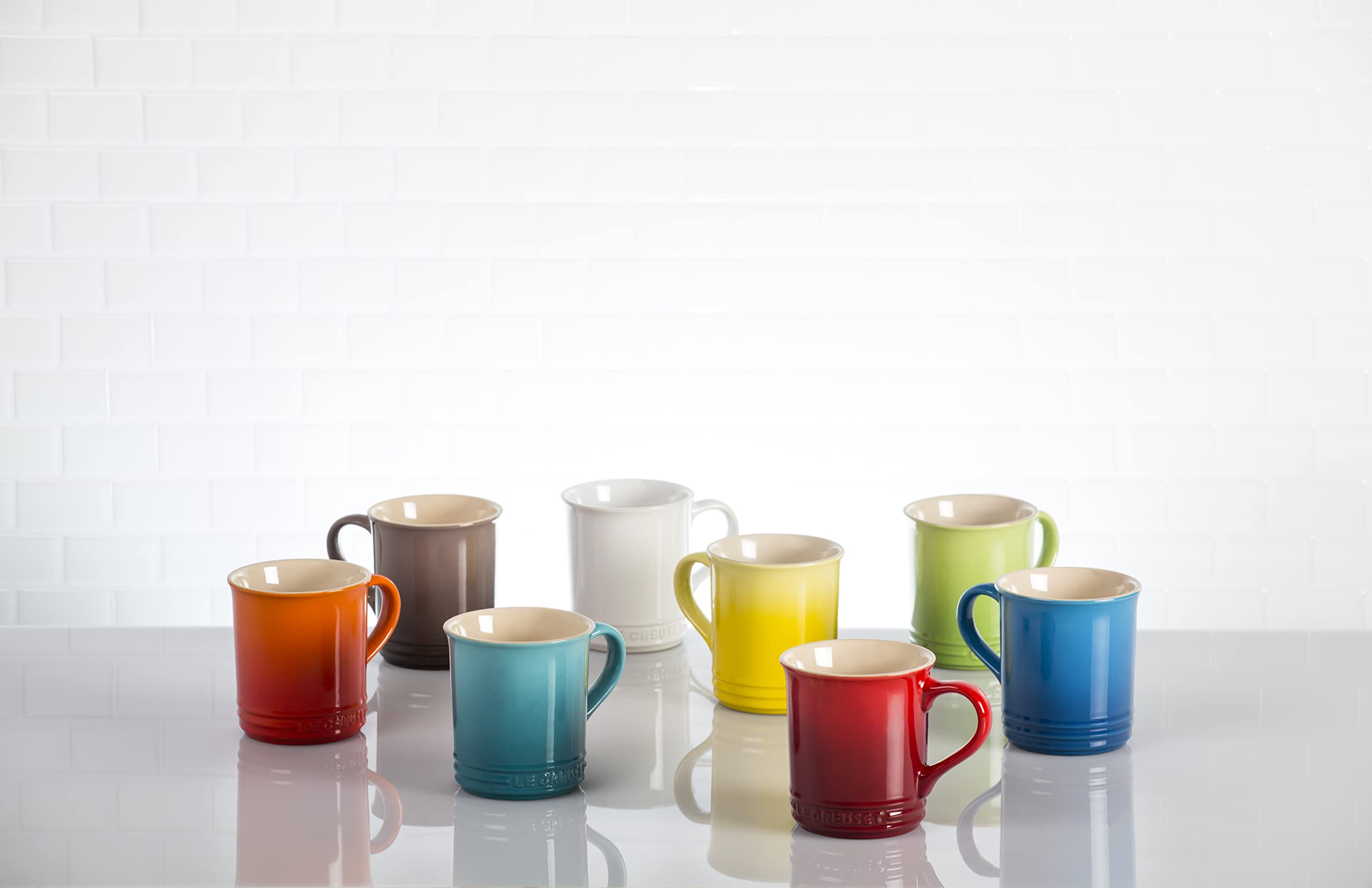 Le Creuset Vancouver Mug Peche next to a hand for size comparison and practical scale