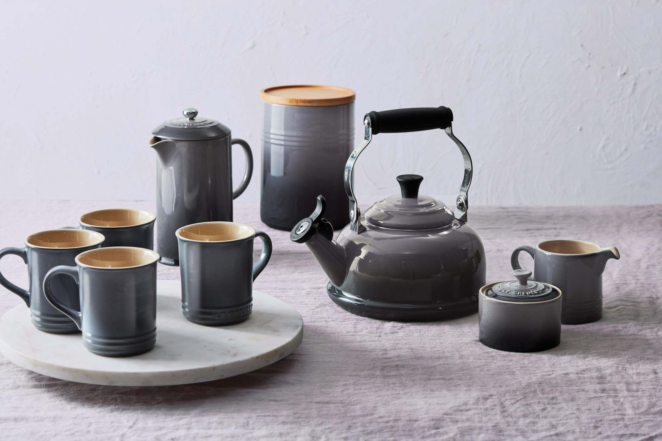Le Creuset mug stacked beside plates to show coordinated dinnerware styling